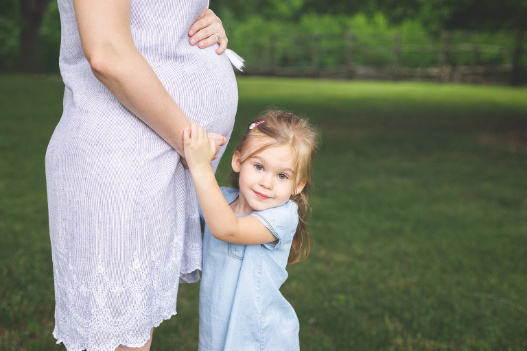 Little girl hugging pregnant mom's belly | St Louis Family Photographer