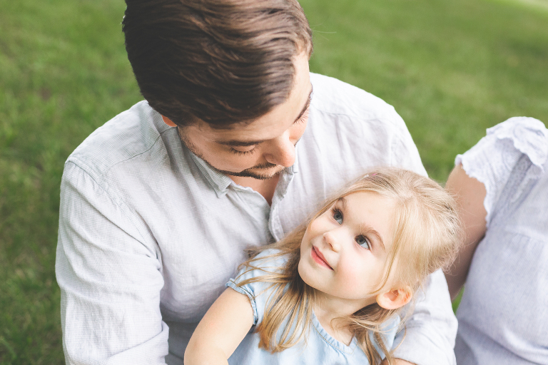 Little girl sitting on her daddy's lap looking up at him | St. Louis Photography