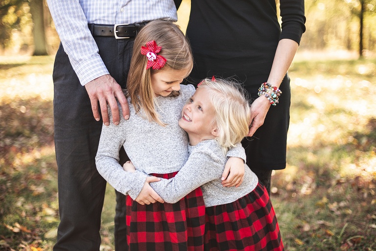 Little sister looking up and smiling at big sister | St. Louis Photographer