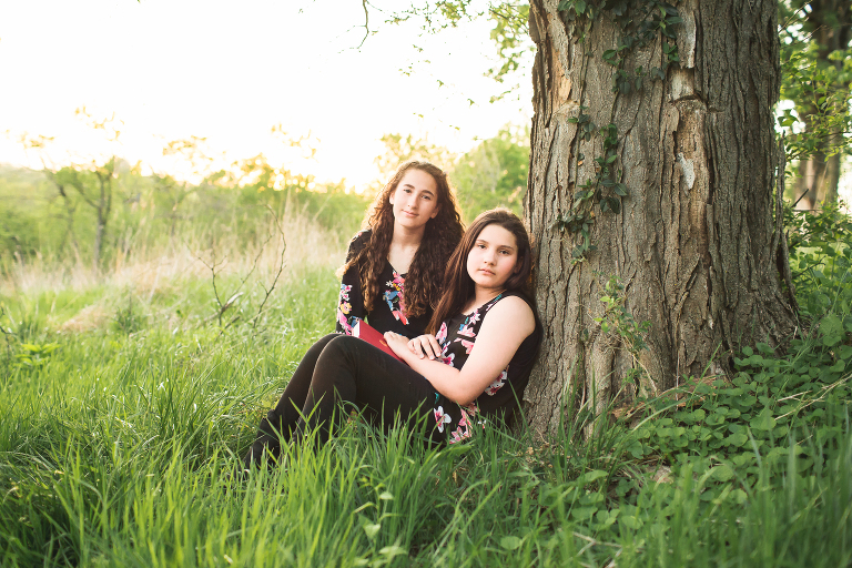 Two sisters sitting under a tree at Queeny Park KGriggs Photography | St. Louis Family Photography