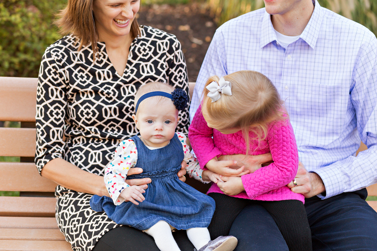 Sisters sitting on parent's laps | St. Louis Children's Photographer