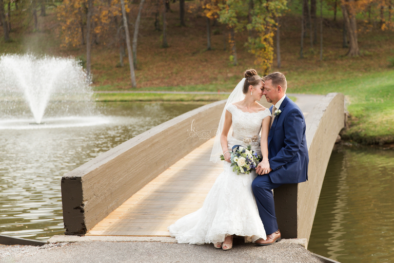 bride and groom sitting on bridge during sunset | St. Louis Photography