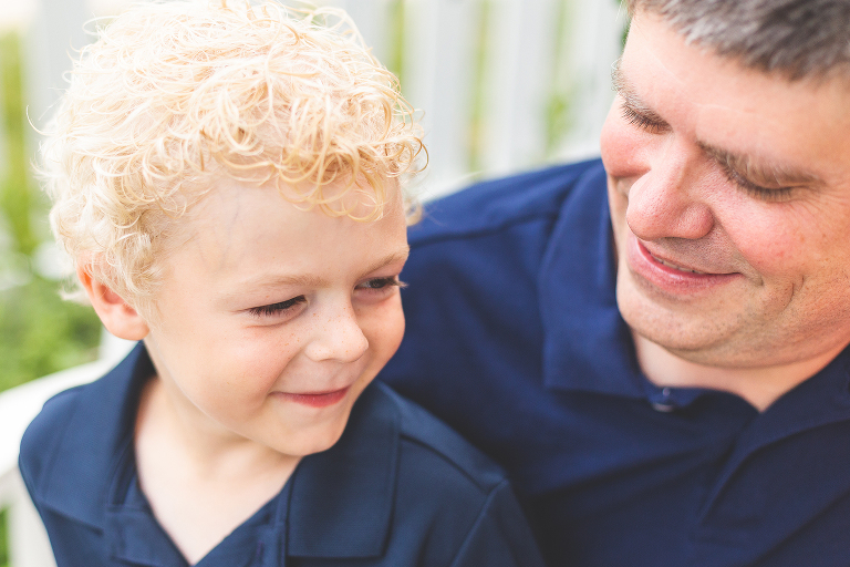 Little boy sitting on his daddy's lap and smiling | St. Louis Family Photographer