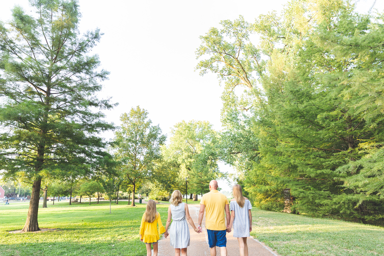 Family walking hand in hand in St. Charles park.