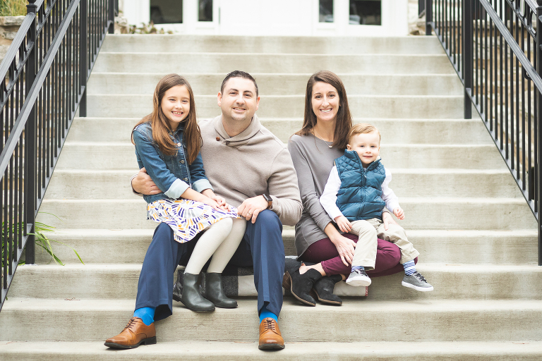 Mom, Dad, daughter and son all sitting and smiling at Oak Knoll Park | St. Louis Family Photographer