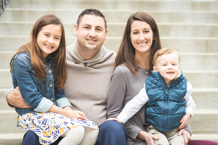 Family of four snuggled up on steps at Oak Knoll Park | St. Louis Photos